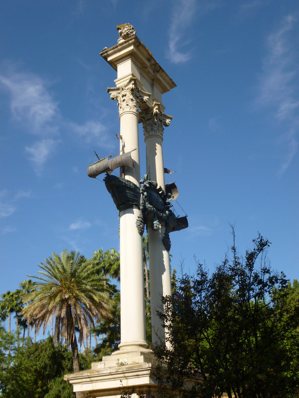 White double pillar with a dark green boat statue three quarters of the way up