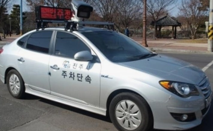Unmarked mobile illegal parking enforcement patrol car with a roof-mounted camera in Korea