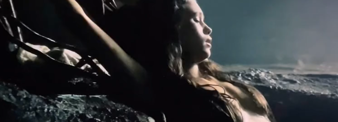 A hot girl lying naked in the water and showing her boobs.