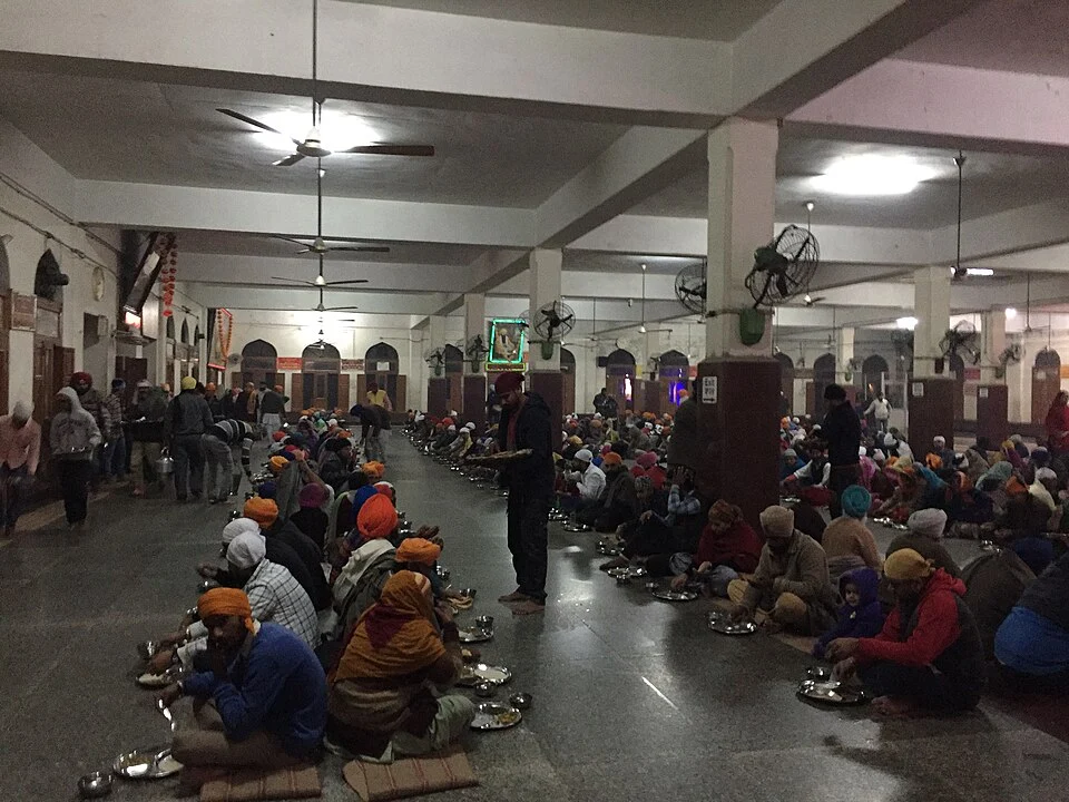 People enjoying langar at the Golden Temple in Amritsar People sitting together and eating langar at Golden Temple