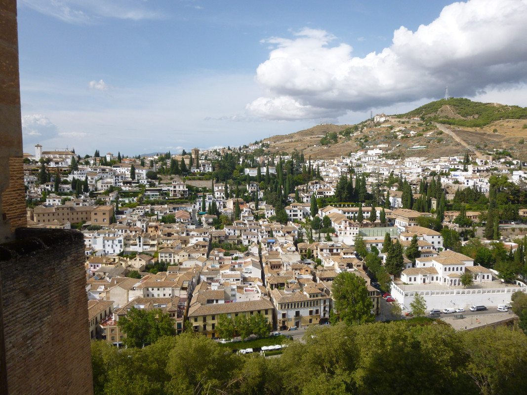 View over part of Grenada.  The buildings are white walled and have orange tiled roofs.