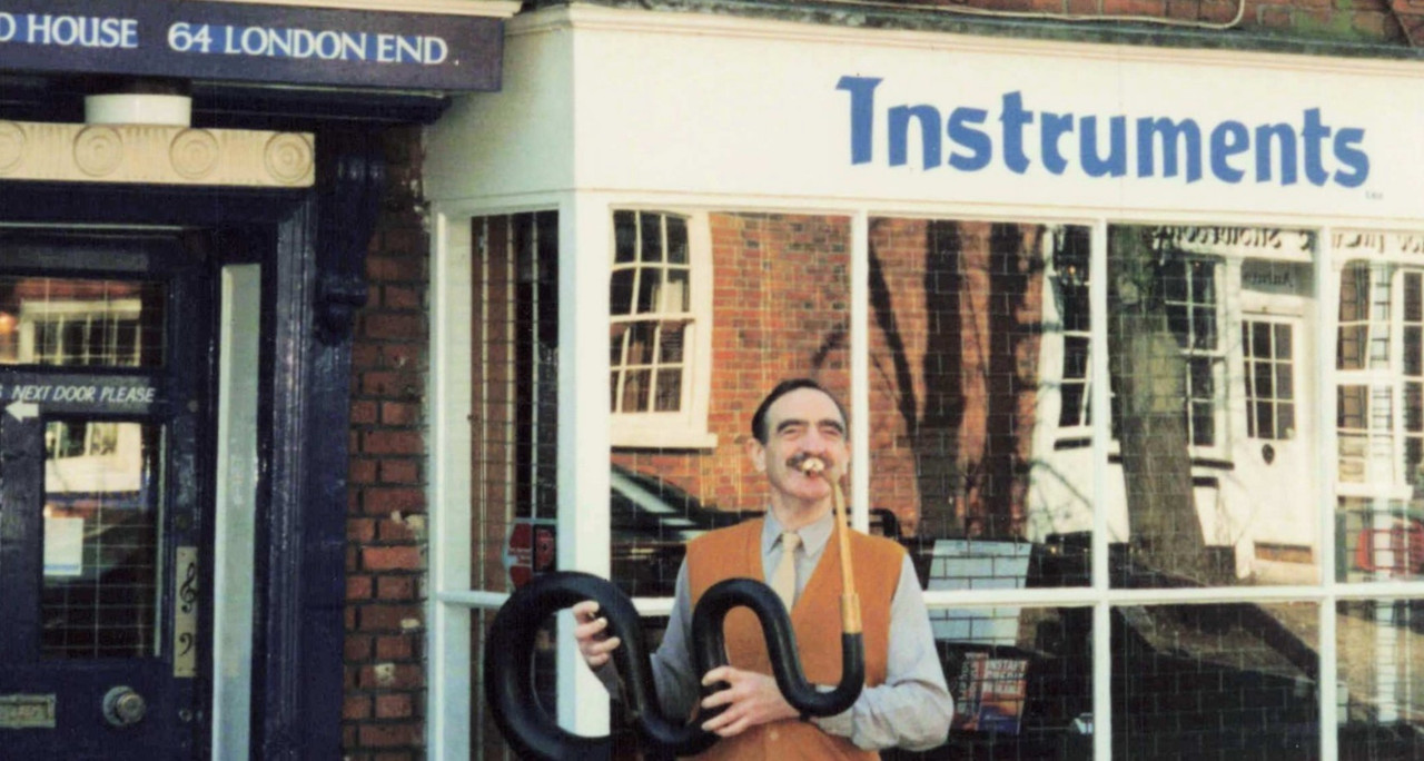 Trevor standing outside Rosehill Instruments holding a musical serpent