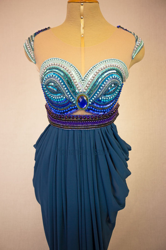 Long evening dress in turquoise with sweetheart neckline, bare shoulders and embroidery details in rhinestones.