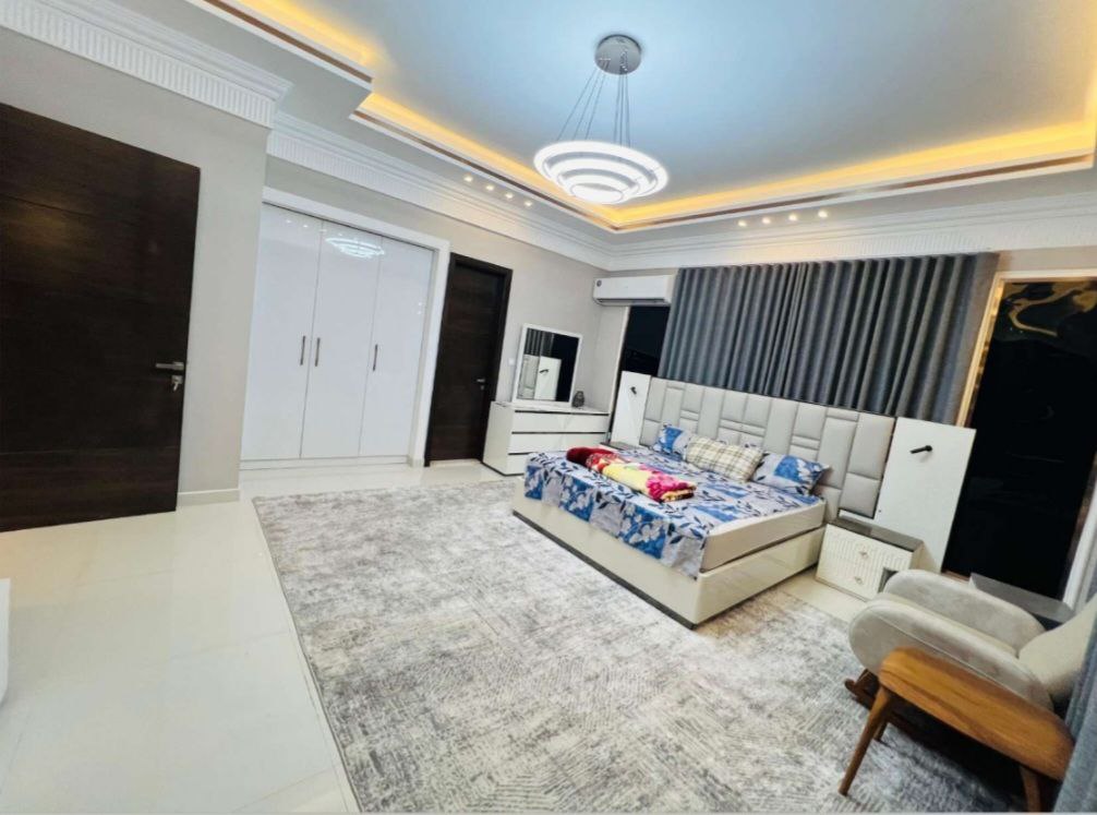 غرفة واسعة داخل فيلا فاخرة في عجمان، بتصميم عصري وأثاث أنيق يوفر راحة وخصوصية مثالية للإقامة.