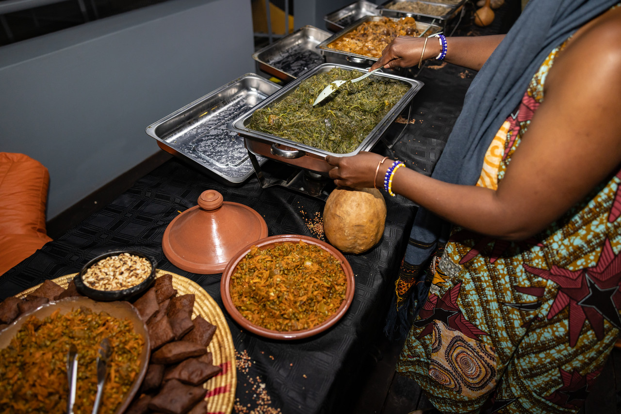Person dishing up a plate of food from a buffet table