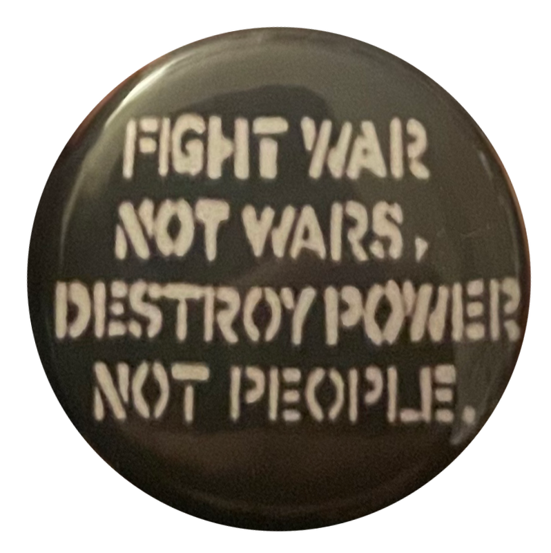 a black pin with white text that says 'fight war not wars, destroy power not people'