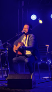 Ailton Souza em apresentação intimista com violão e iluminação azul