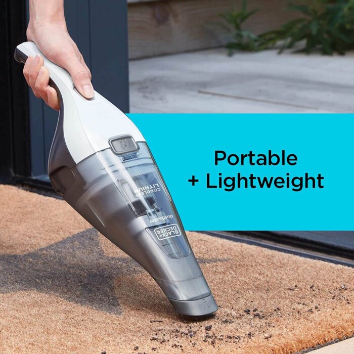 Persona usando la aspiradora de mano Black+Decker para limpiar un sofá.