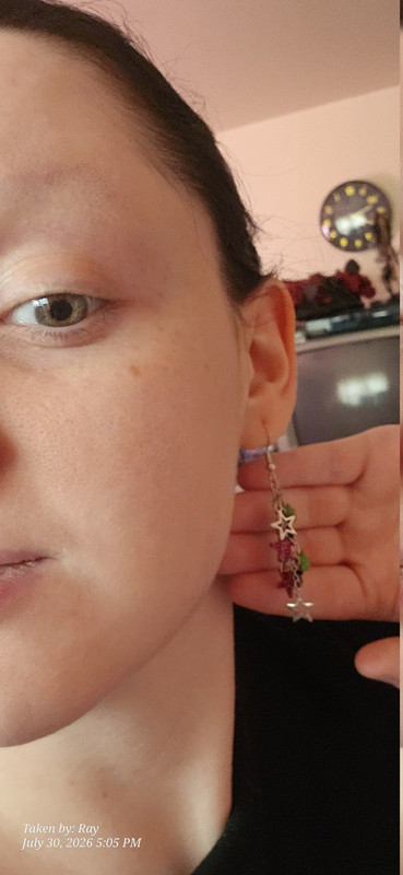 a closeup of my earrings for the lisa frank outfit. They're dangly little stars, some are neon green star shaped beads, some silver hollow star shapes and flat textured bright fuchsia with tactile black cheeta print on them.