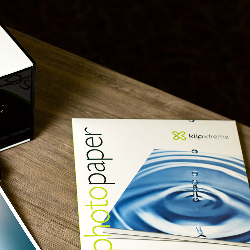 Una mano sosteniendo una fotografía con colores vivos y un acabado brillante.