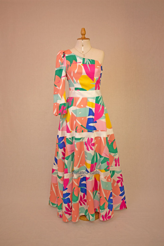 Asymmetric long dress with floral print in vibrant colors, one-shoulder neckline and long sleeves.