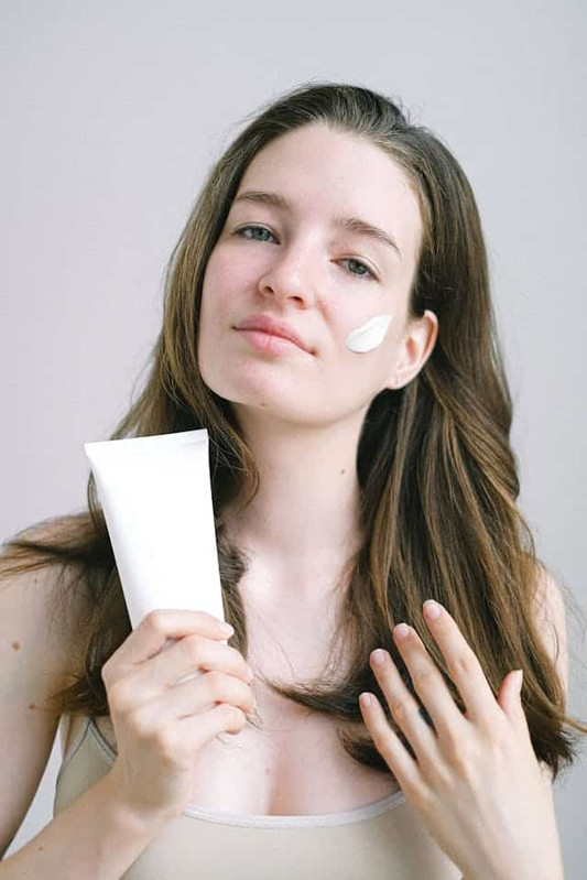 a girl taking care of her skin barrier by applying cream