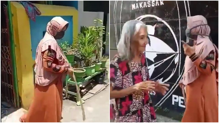 Seorang ibu mengingatkan warganya agar patuhi social distancing