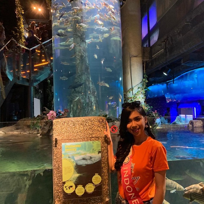 Gabriella saat berpose di depan tabung raksasa berisi ragam ikan
