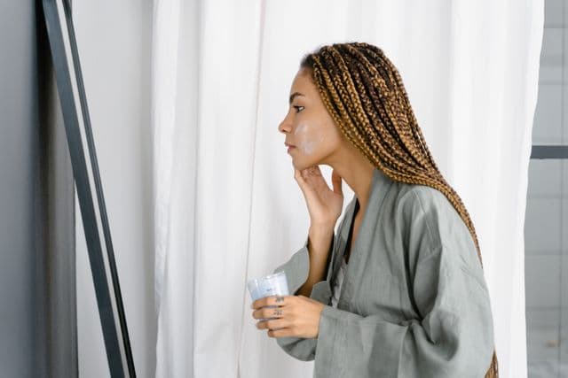 Woman applying face cream to soothe and repair the skin barrier with barrier-supporting ingredients.