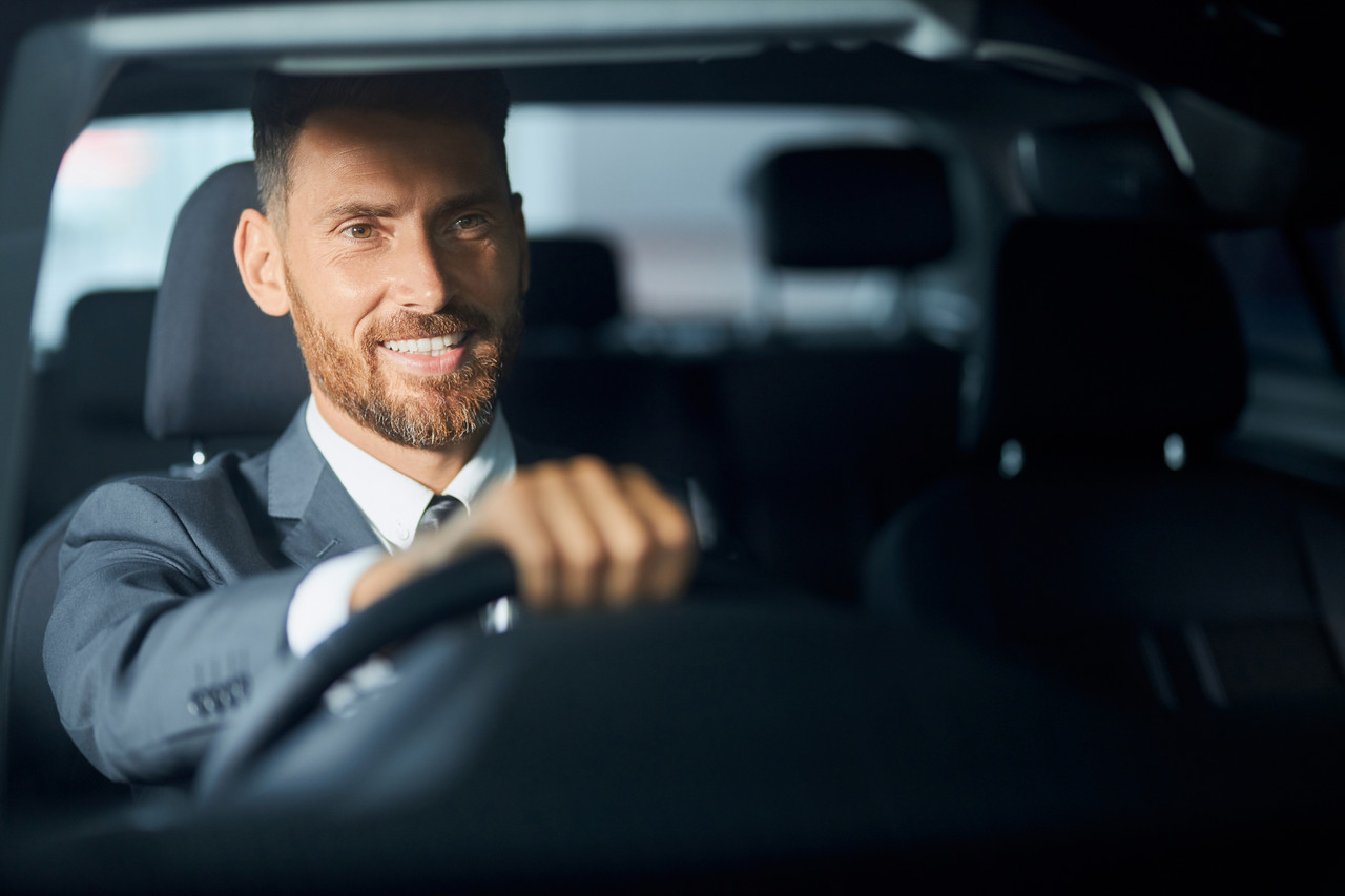 smiling businessman suit examining auto before purchase