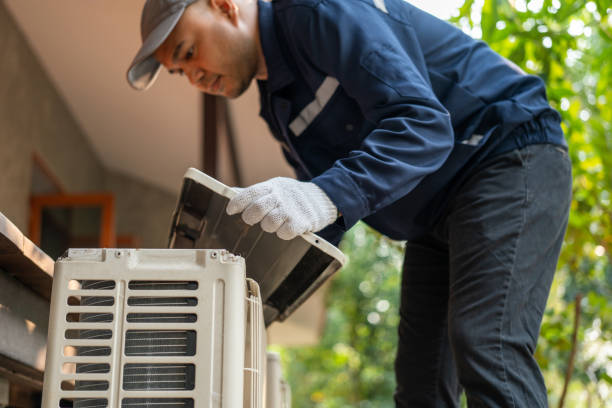 Technician repairing outdoor AC condenser