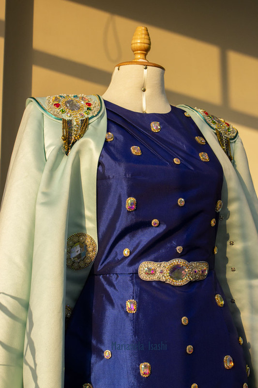 Aqua green blazer with rhinestone embellishments on the shoulders and decorative buttons.
