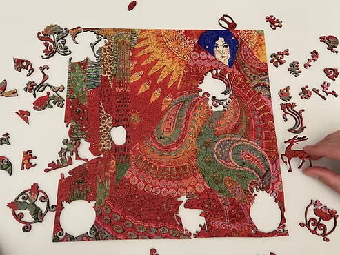 Hand assembling a vivid red and gold ClairDeBois puzzle inspired by Vittorio Zecchin