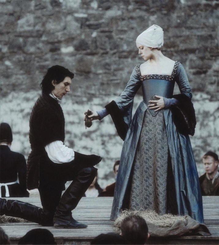 Rey is standing on a wooden stage and handing a pouch to a kneeling Ben 