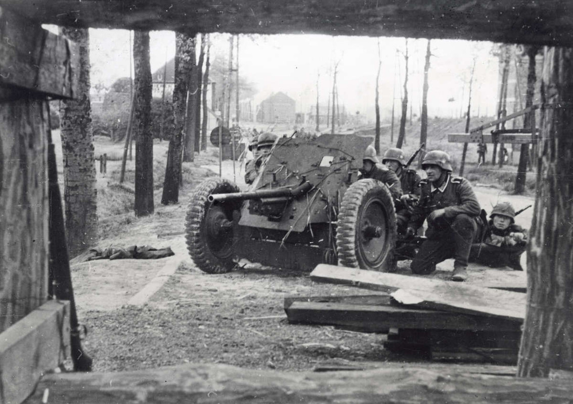 andoorlog België. Een Duits anti-tank kanon in stelling, een Belgisch stadje. 1940.
