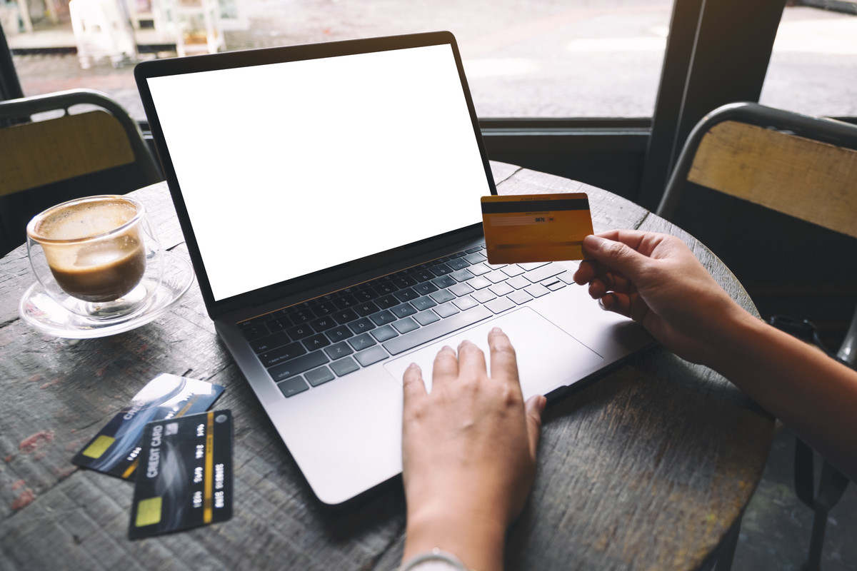 a-woman-holding-credit-card-while-using-and-typing-2022-10-06-22-24-48-utc