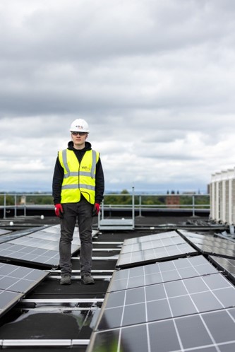 Un technicien sur le toit avec des supports et des panneaux solaires