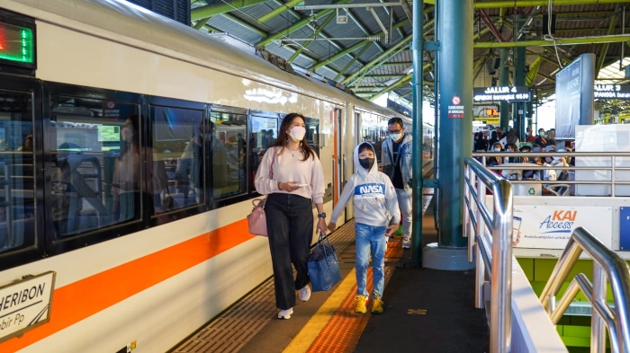 Dua orang wisatawan akan menikmati layanan perjalanan bersama kereta api.