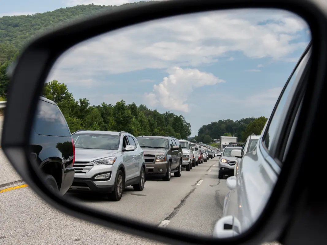 View of cars in rearview window at cars in traffic