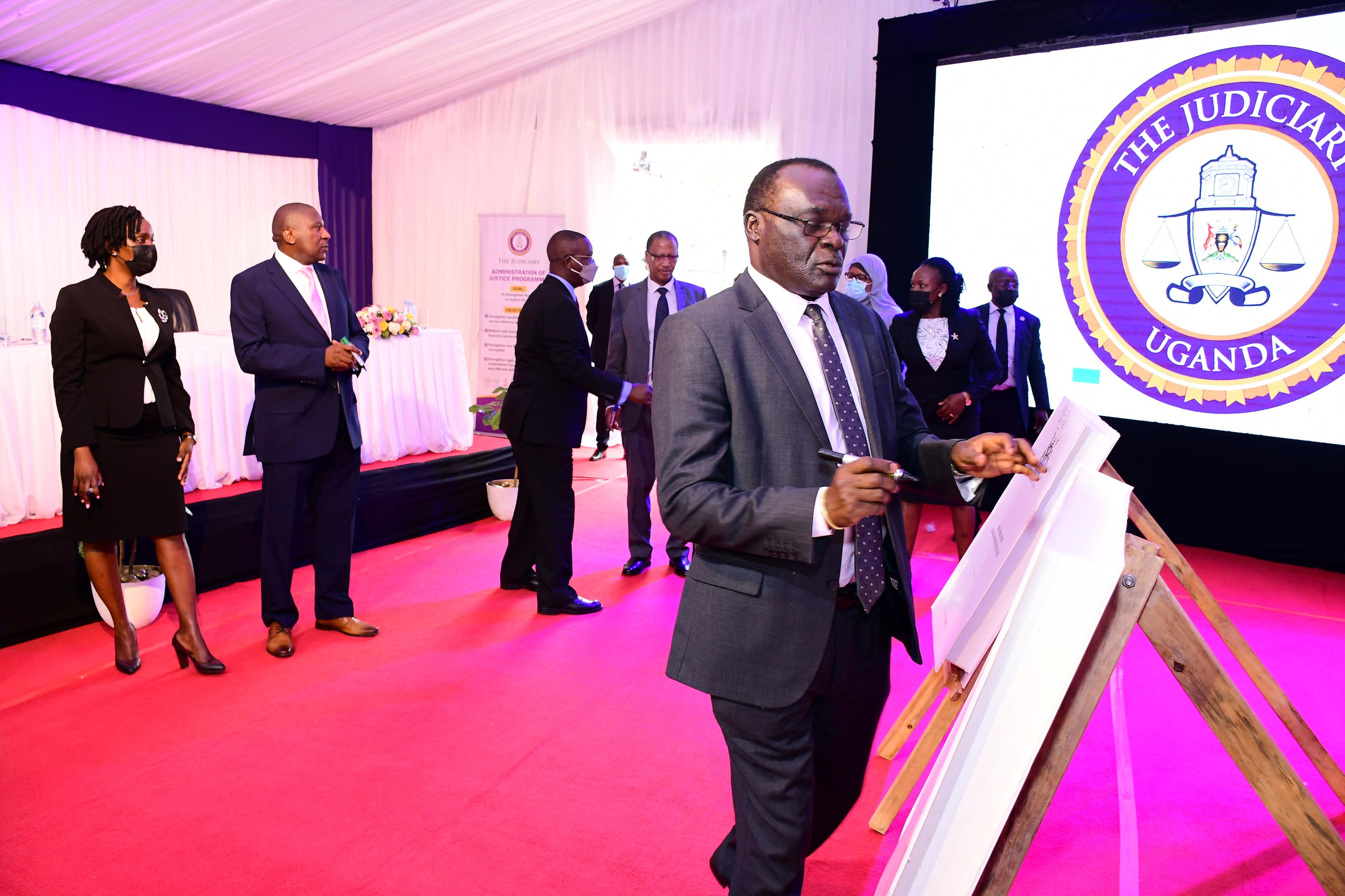   Chief Justice Alfonse Owiny-Dollo signs on a dummy copy of the Constitution (Bail Guidelines for Courts of Judicature), Practice Directions, 2022, during its launch at High court in Kampala on July 27, 2022.   PHOTO/ABUBAKER LUBOWA