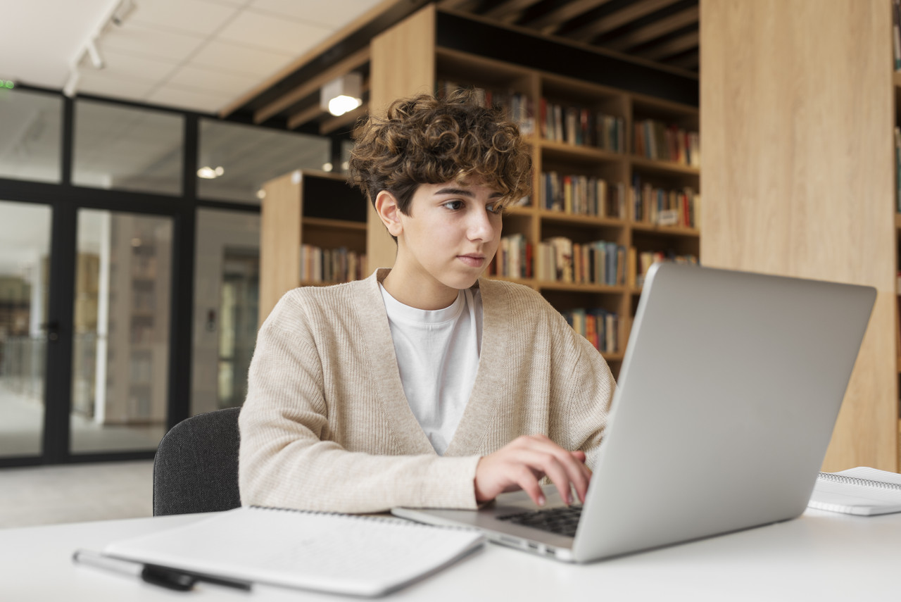 young student learning library