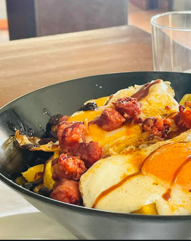 Huevos rotos con chistorra y pasas (ración)