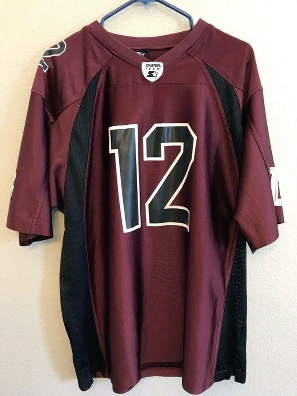 Blue robot-like figure with red shoes on a wooden platform with lights, on a white background