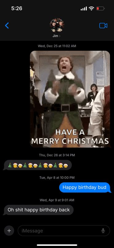 Text message between Trevor and Jamie, displaying Jim at the top with a thumbnail of the two celebrating in their Ducks uniforms. Dated Wed Dec 25 11:02 am. T: GIF of Will Ferrell shouting in the movie Elf, with the words Have a Merry Christmas superimposed over him. Dated Thurs Dec 26 at 3:15 pm. J: alternating Christmas tree, Santa Claus, and Mrs Claus emojis. Dated Tues Apr 8 at 10:00 pm. T: Happy birthday bud Dated Wed Apr 9 at 9:01 am. J: Oh shit happy birthday back