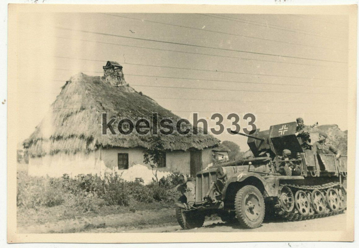 Foto Panzer Halbkette mit 2cm Flak Geschütz vor einem Bauernhaus in Russland