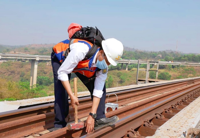 Petugas Pemeriksa Jalur mengencangkan baut-baut rel agar aman saat dilewati kereta api.