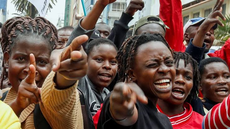 Kenyan youth protesters holding signs rejecting Raila Odinga