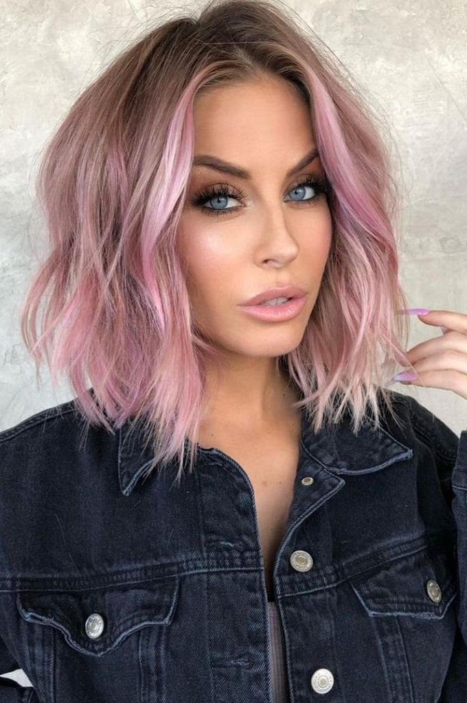 Pastel pink color on medium length wavy hair