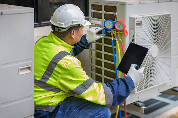 HVAC technician repairing air conditioning condenser unit