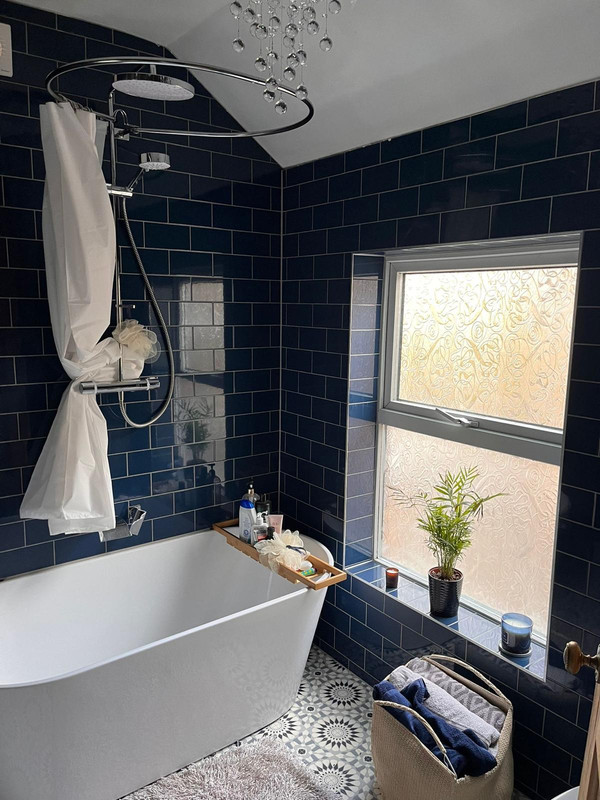 Luxury navy tiled bathroom renovation with freestanding bath and window