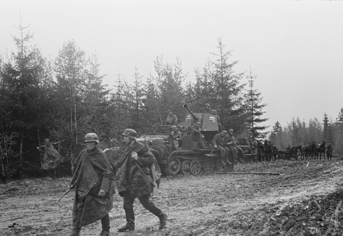 La progression de fantassins allemands soutenus par des blindés Panzer-III et un semi-chenillé Sd.kf