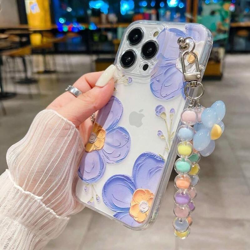 Foto de Funda transparente con diseño flora. Incluye correa de mano.