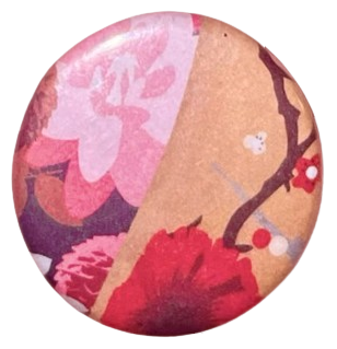 a pin i made at a festival as a small child, both halves of it with different flower patterns. on the right, a pattern with a light brown background, dark brown branches, and a red flower. on the left, a pattern with a dark brown background and pink flowerrs