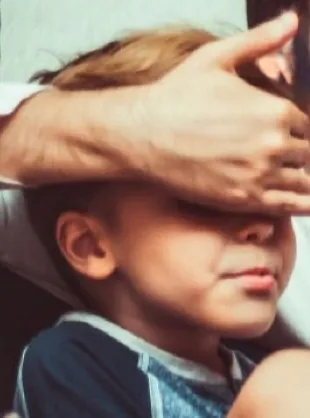 father covering sons eyes
