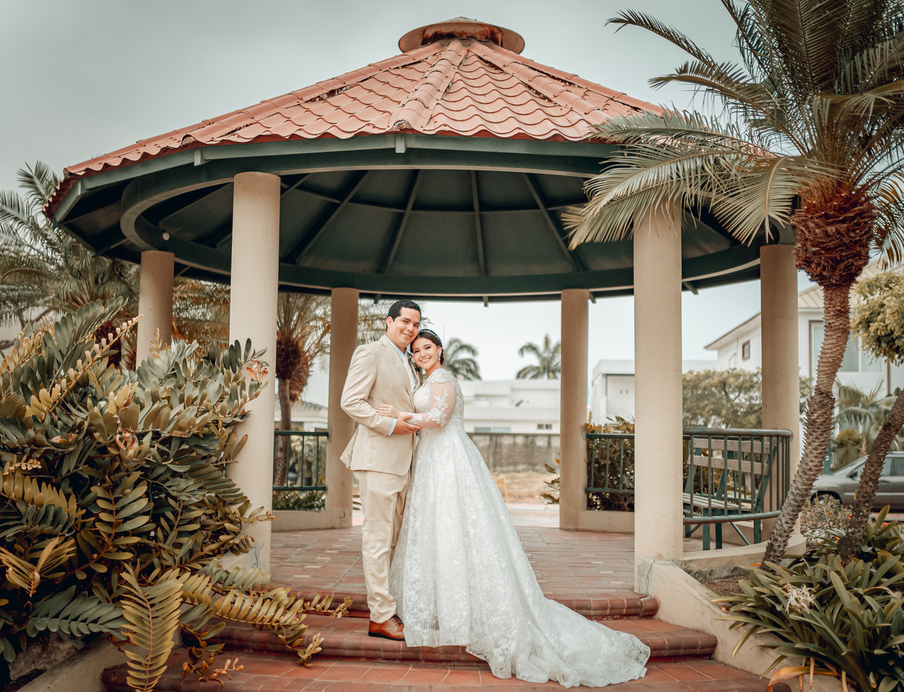 Esposos abrazados, románticos a la entrada de una pérgola