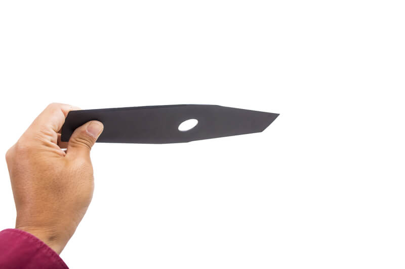 A close-up of a man`s hand holding the blade of a lawn edger