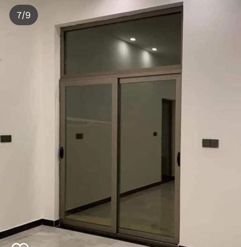 باب ألمنيوم سحاب كبير مع جزء علوي ثابت داخل ممر داخلي