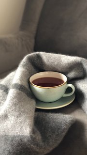 A cup with some tea and a blanket
