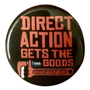 a pin that say 'direct action gets the goods' in red text with a red tool underneath that says 'fuck shit up' on it