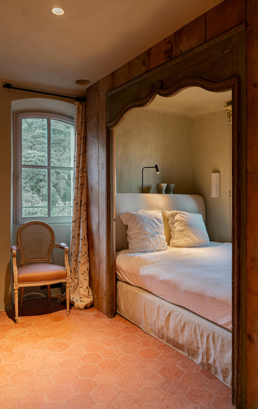 Luxuriöses Schlafzimmer-Lichtdesign in Château Bénat mit warmem Nachttischlicht, historischen Materialien und sorgfältig kontrollierter Helligkeit